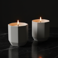 Two white octagonal soy candles on dark marble - hero shot